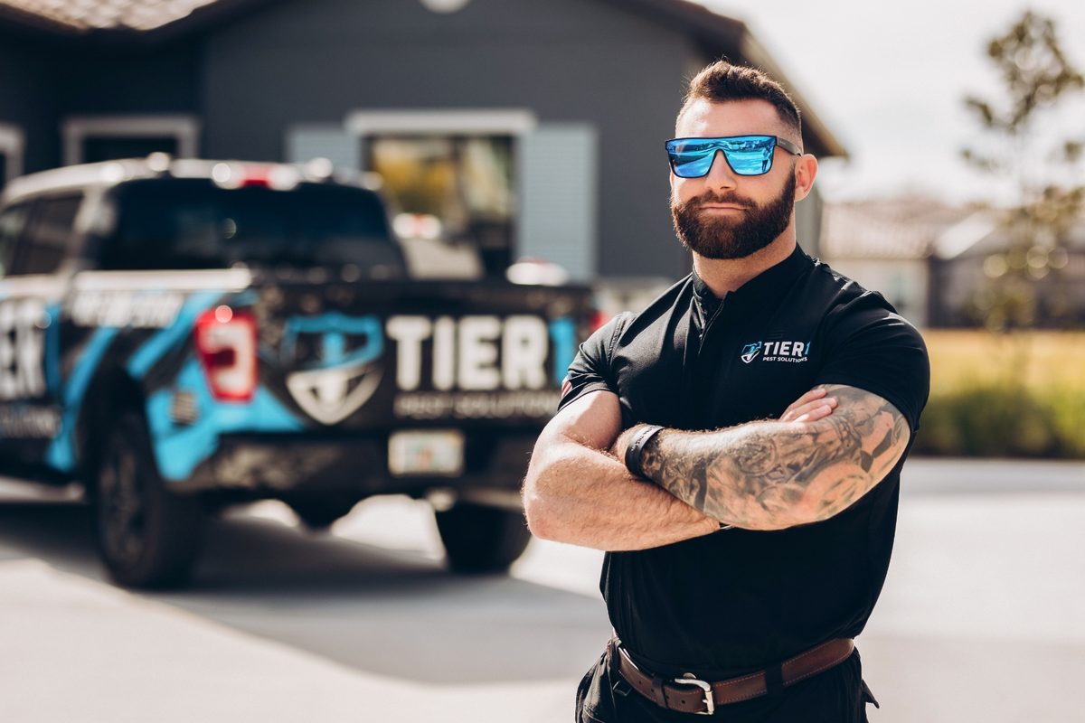 Tier 1 Pest Solutions technician with branded truck